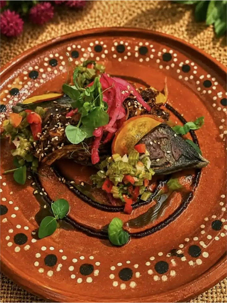 Antojitos de maíz de Anega servidos en un plato de barro decorado